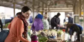 Woman looking at vegetables at a market.