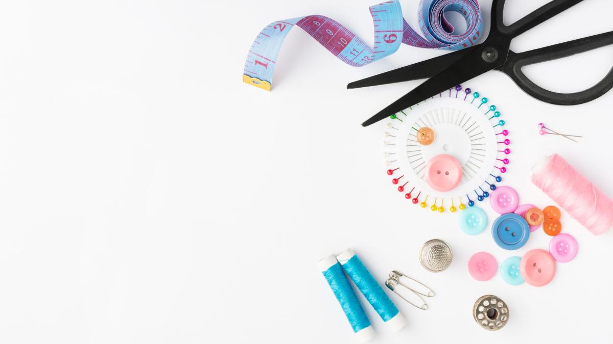 View from above of various sewing supplies on a white background.