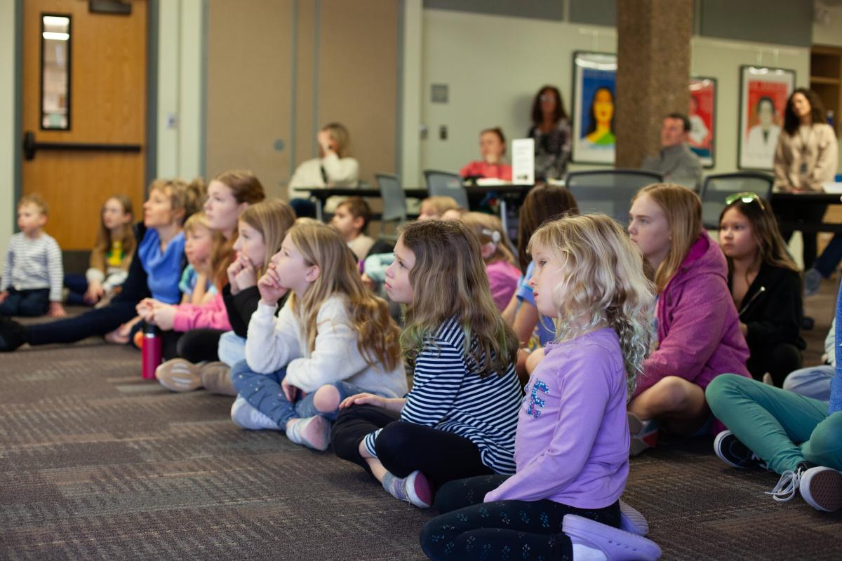 Kids look at presenter (not shown) as they listen to story